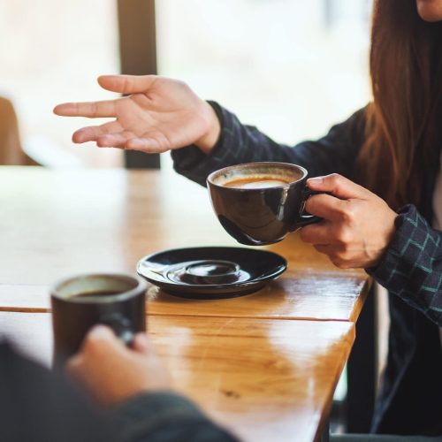 Closeup image of people enjoyed talking and drinking coffee together in cafe